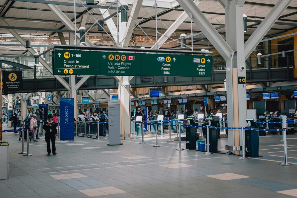 Airport terminal with large directional signs for check-in and departure gates, illustrating navigation and wayfinding during travel.